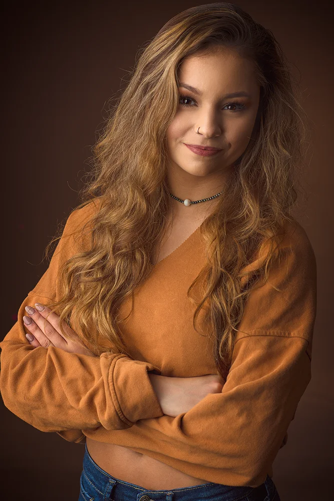 Informal studio portrait of young female model in orange top