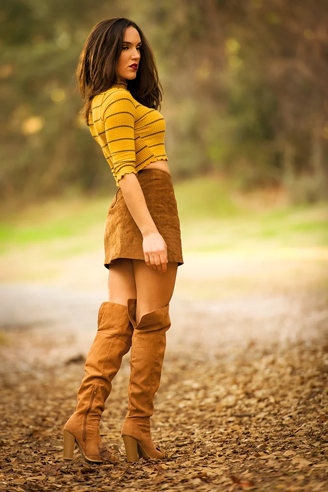 Outdoor portrait of a fashion model in a fall outfit and knee high boots