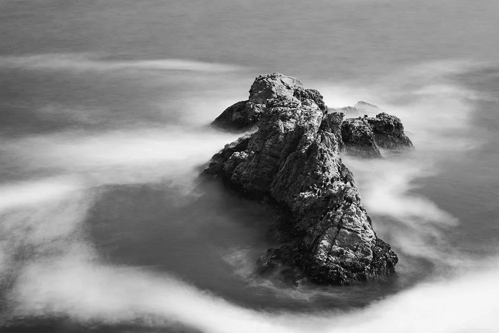 Long exposure image of a single Pacific Ocean Boulder with blurred waves.