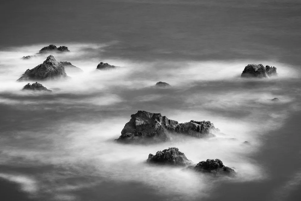 Long exposure image of multiple boulders in the Pacific Ocean