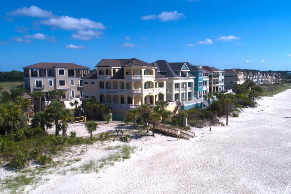 Low level aerial view of a row of colorful ocean front homes on Hilton Head Island