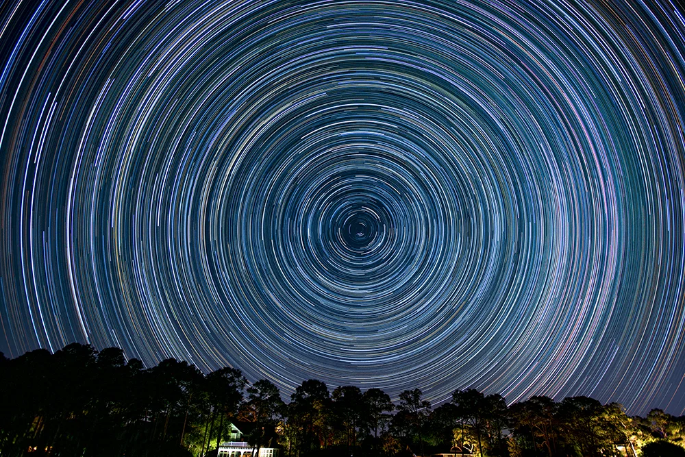 Star trails long exposure image taken from Atlantic Ocean beach showing rotation around the North Star