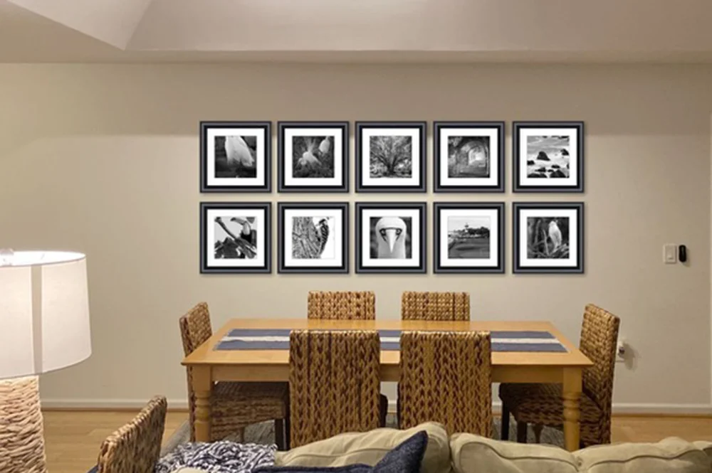 Dining room with two rows of 5 black and white fine art photography images on wall  