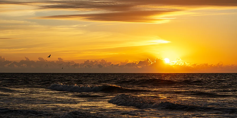 Brilliant yellow sunrise over the Atlantic Ocean as seen from the beach on Hilton Head Island